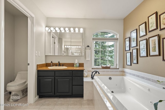 bathroom featuring tile patterned flooring, a whirlpool tub, toilet, and vanity