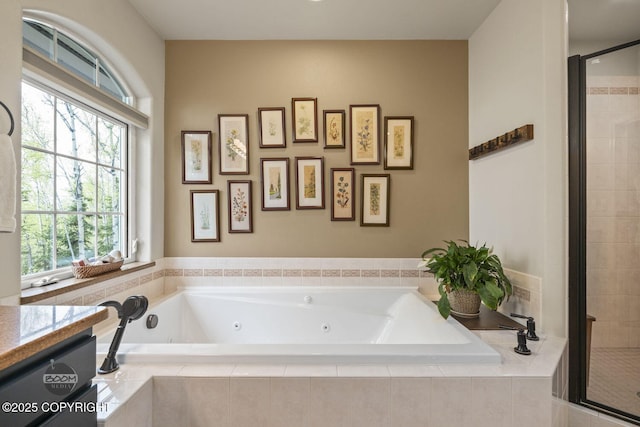 bathroom with a stall shower, a jetted tub, and vanity