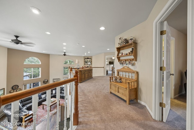hall with an upstairs landing, light carpet, recessed lighting, and baseboards