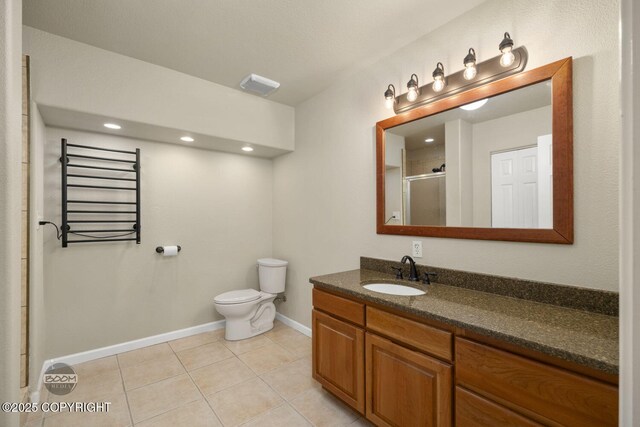 bathroom with a shower stall, baseboards, toilet, tile patterned flooring, and vanity