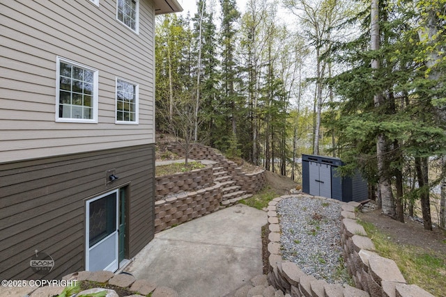 view of patio with a shed and an outbuilding