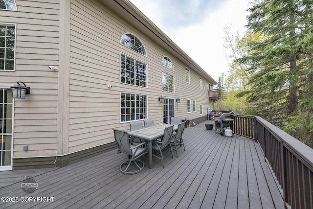 deck featuring outdoor dining area and area for grilling