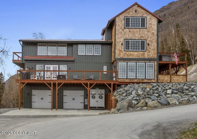 23231 Glacier View Dr, Eagle River, AK 99577 - rear view of property with driveway, a deck with mountain view, board and batten siding, and a garage