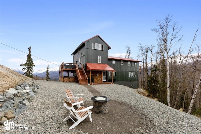 23231 Glacier View Dr, Eagle River, AK 99577 - back of property featuring an outdoor fire pit, stairs, a patio, and a wooden deck