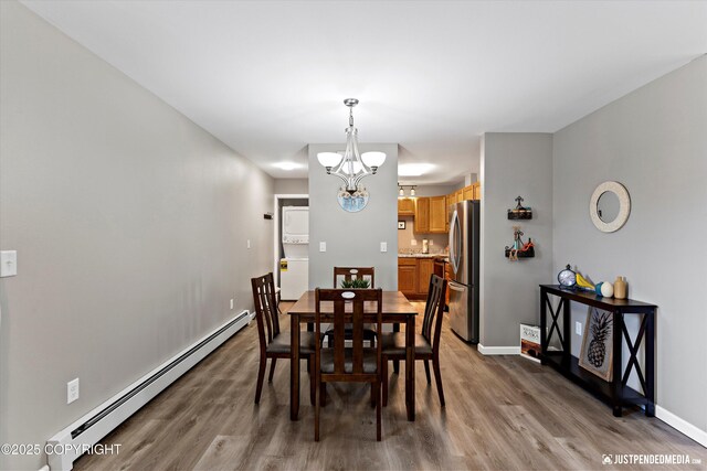 4530 Wright St # 15, Anchorage, AK 99507 - dining area with wood finished floors, an inviting chandelier, stacked washer / dryer, and a baseboard radiator