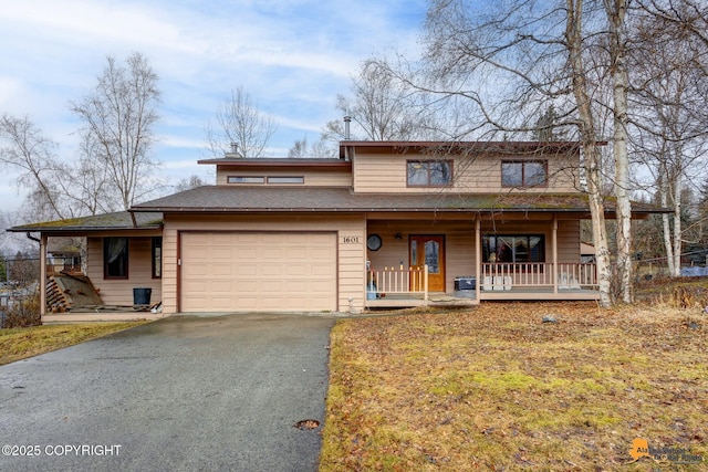 traditional-style house featuring a garage, a porch, and driveway