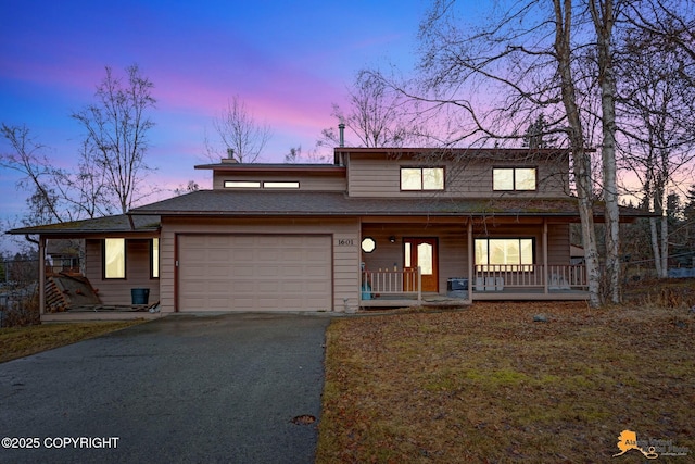 view of front facade with a porch, an attached garage, and driveway