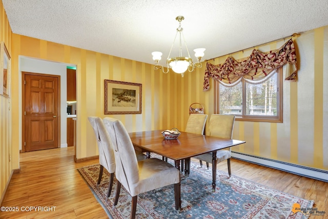 dining room with an inviting chandelier, baseboard heating, light wood finished floors, a textured ceiling, and wallpapered walls
