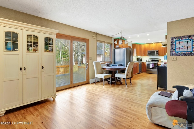 dining area featuring recessed lighting, a textured ceiling, and light wood-type flooring