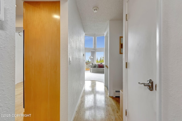 13120 Saunders Rd, Anchorage, AK 99516 - hall with baseboard heating, a textured wall, wood finished floors, and a textured ceiling