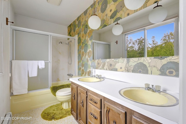 13120 Saunders Rd, Anchorage, AK 99516 - full bath with wallpapered walls, toilet, bath / shower combo with glass door, double vanity, and a baseboard heating unit