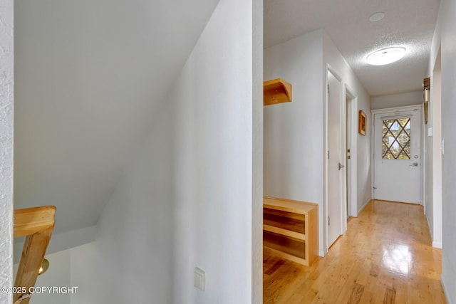 13120 Saunders Rd, Anchorage, AK 99516 - hallway featuring light wood-style flooring, a textured ceiling, and baseboards