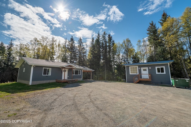 ranch-style home with dirt driveway