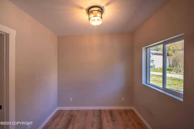 unfurnished room featuring wood finished floors and baseboards
