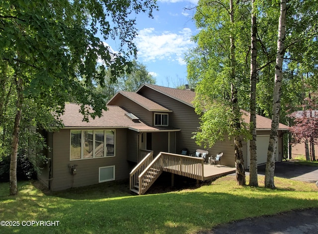 19532 Ostovia Cir, Eagle River, AK 99577 - rear view of property with a wooden deck, a yard, an attached garage, a shingled roof, and driveway