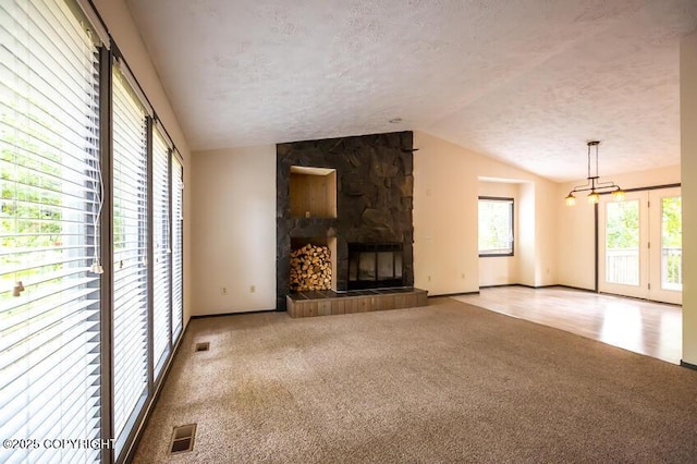19532 Ostovia Cir, Eagle River, AK 99577 - unfurnished living room featuring a fireplace, a textured ceiling, visible vents, carpet flooring, and lofted ceiling