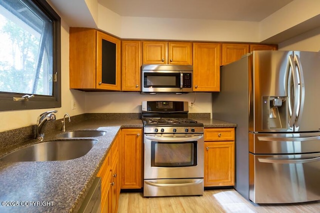 19532 Ostovia Cir, Eagle River, AK 99577 - kitchen with dark stone countertops, glass insert cabinets, brown cabinetry, appliances with stainless steel finishes, and a sink