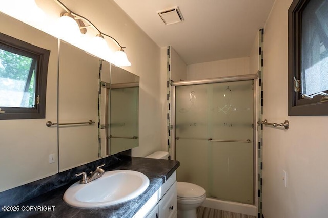 19532 Ostovia Cir, Eagle River, AK 99577 - bathroom featuring visible vents, toilet, a shower stall, and vanity