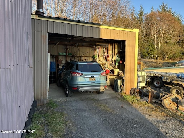 view of vehicle parking with a garage and an outbuilding