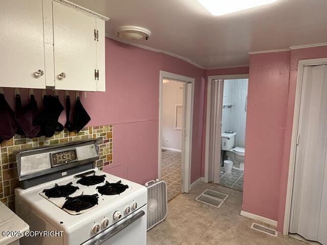 22539 Needles Loop, Chugiak, AK 99567 - kitchen featuring light tile patterned floors, visible vents, white cabinetry, ornamental molding, and gas range oven