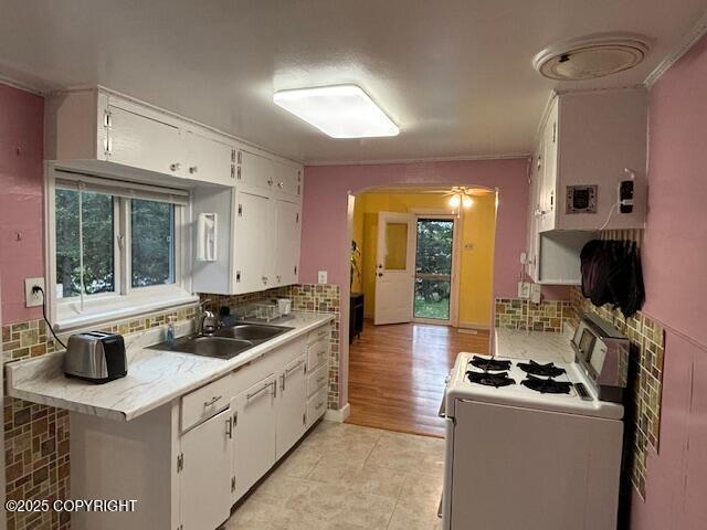 22539 Needles Loop, Chugiak, AK 99567 - kitchen featuring tasteful backsplash, range, light countertops, and a sink