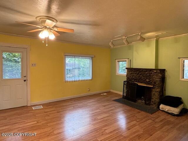 22539 Needles Loop, Chugiak, AK 99567 - unfurnished living room featuring wood finished floors, ceiling fan, and plenty of natural light