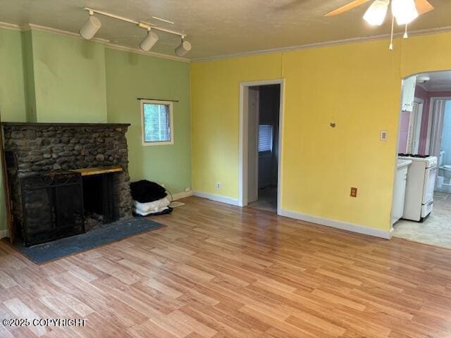 22539 Needles Loop, Chugiak, AK 99567 - unfurnished living room featuring light wood-style floors, a ceiling fan, ornamental molding, and arched walkways