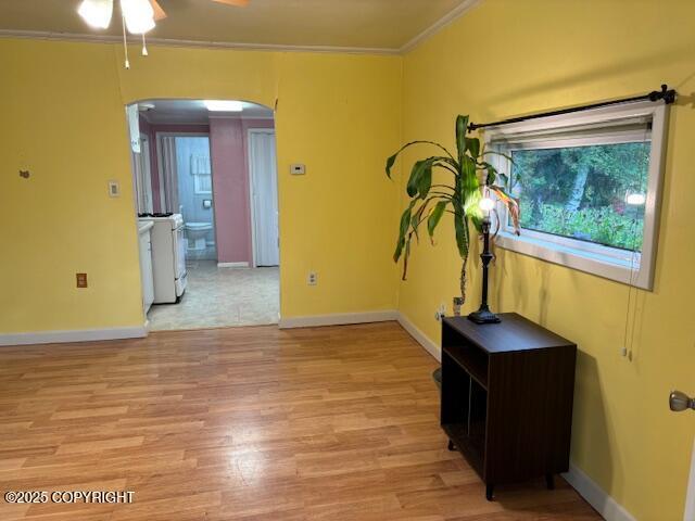 22539 Needles Loop, Chugiak, AK 99567 - unfurnished room with ceiling fan, baseboards, arched walkways, light wood finished floors, and ornamental molding