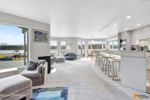 living room with a healthy amount of sunlight, recessed lighting, and light colored carpet