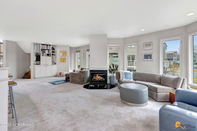 carpeted living area featuring a glass covered fireplace, recessed lighting, and a wealth of natural light