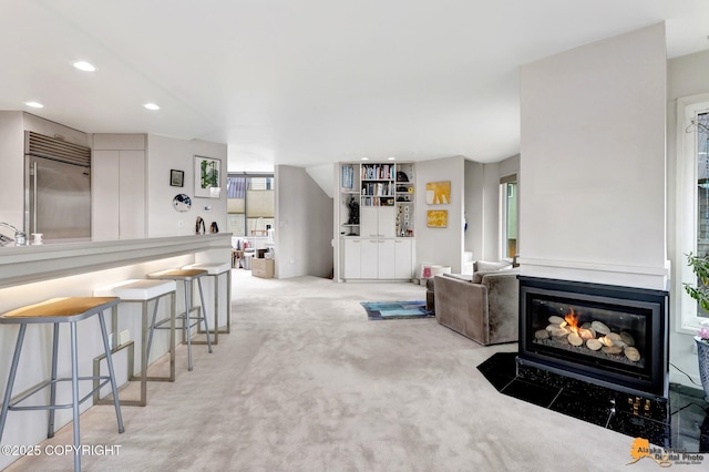 living room with carpet flooring, recessed lighting, and a fireplace with flush hearth