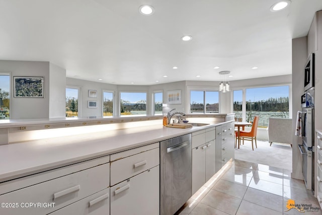 kitchen featuring light colored carpet, a sink, stainless steel appliances, recessed lighting, and light tile patterned floors
