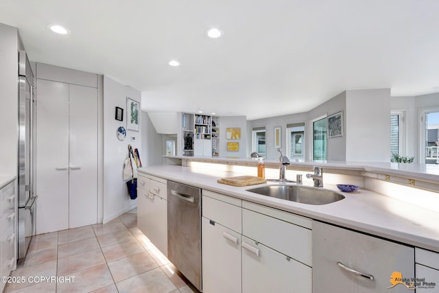 kitchen with light countertops, recessed lighting, a sink, and dishwasher