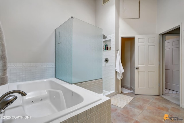 full bathroom featuring a jetted tub, walk in shower, tile patterned flooring, and visible vents