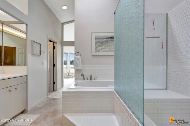 full bathroom with tile patterned floors, a garden tub, and vanity
