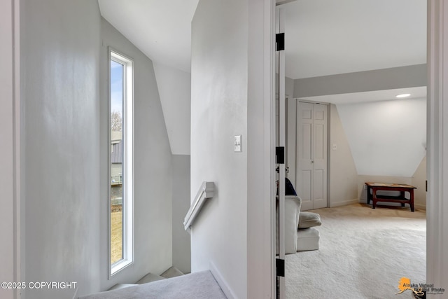 staircase with baseboards, vaulted ceiling, and carpet flooring