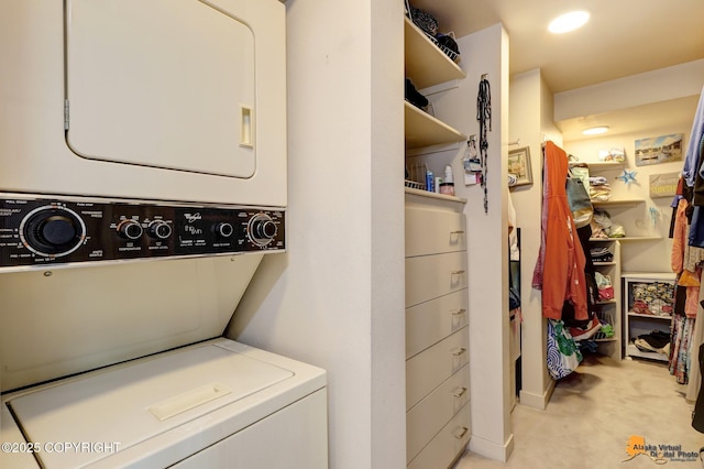 clothes washing area with laundry area, light carpet, and stacked washer / dryer