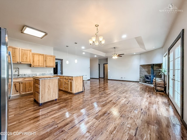 1340 N Rainbow Park Dr, Wasilla, AK 99623 - kitchen with a center island, a stone fireplace, a wealth of natural light, visible vents, and freestanding refrigerator