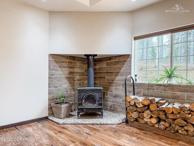 1340 N Rainbow Park Dr, Wasilla, AK 99623 - room details featuring baseboards, a wood stove, wood finished floors, and recessed lighting
