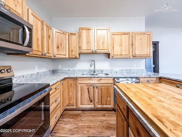 1340 N Rainbow Park Dr, Wasilla, AK 99623 - kitchen with wooden counters, light brown cabinets, a sink, light wood-style floors, and appliances with stainless steel finishes