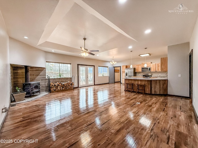 1340 N Rainbow Park Dr, Wasilla, AK 99623 - unfurnished living room with baseboards, recessed lighting, ceiling fan with notable chandelier, wood finished floors, and a wood stove