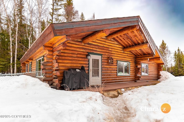 snow covered property featuring log exterior