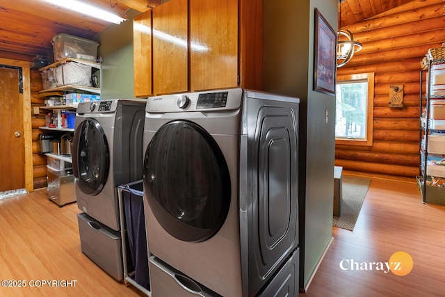 clothes washing area with rustic walls, wooden ceiling, washing machine and clothes dryer, and light wood-style floors
