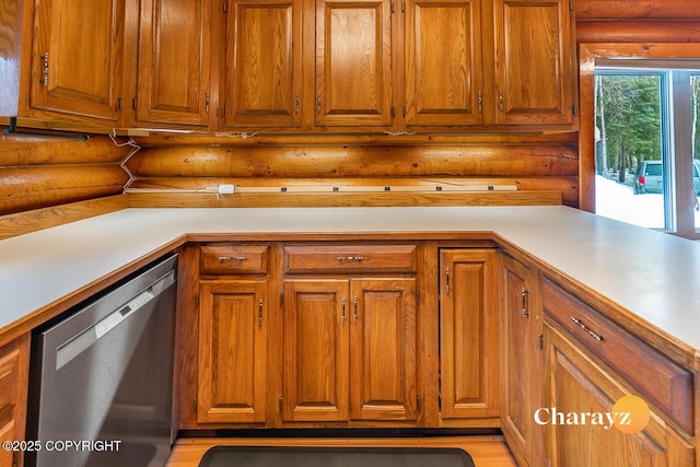 kitchen featuring rustic walls, brown cabinets, stainless steel dishwasher, and light countertops