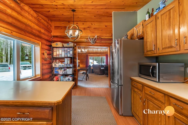 kitchen featuring log walls, light countertops, light wood-style floors, brown cabinets, and stainless steel microwave