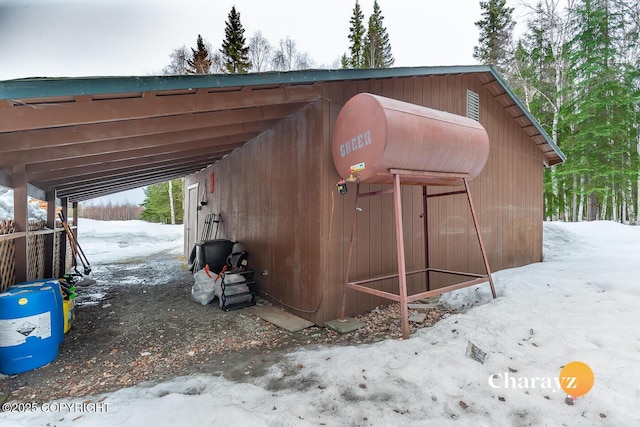 snow covered structure with an outdoor structure and a pole building