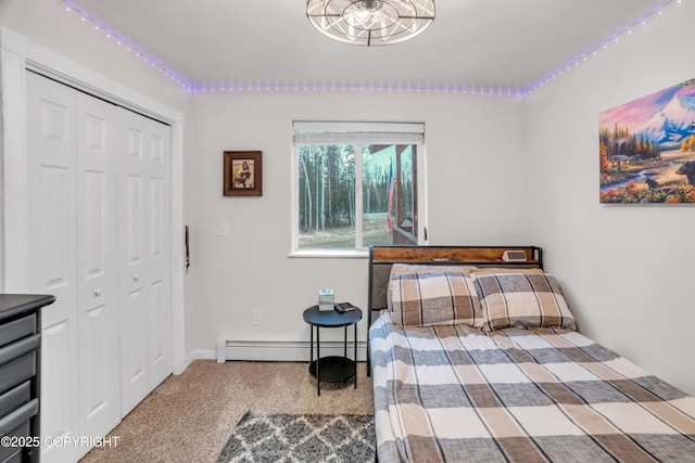 bedroom with a baseboard heating unit, carpet floors, and a closet