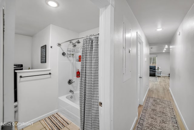 full bathroom featuring shower / bath combo, baseboards, wood finished floors, and recessed lighting