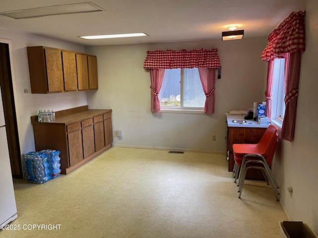 kitchen featuring brown cabinets, baseboards, and visible vents