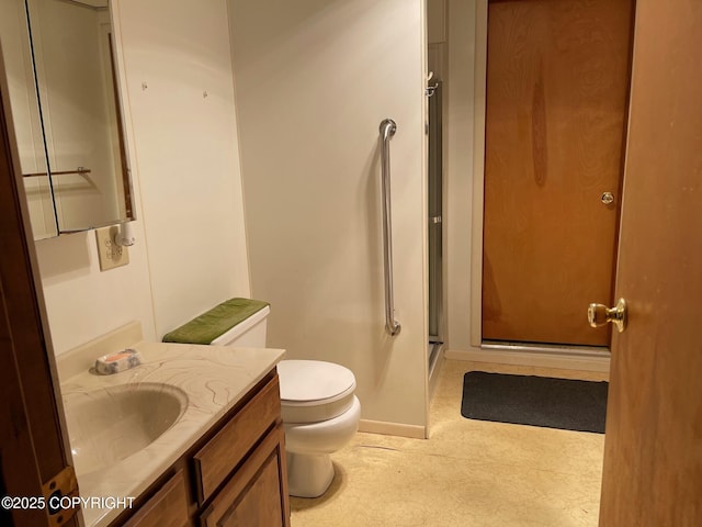 bathroom featuring toilet, vanity, and a stall shower